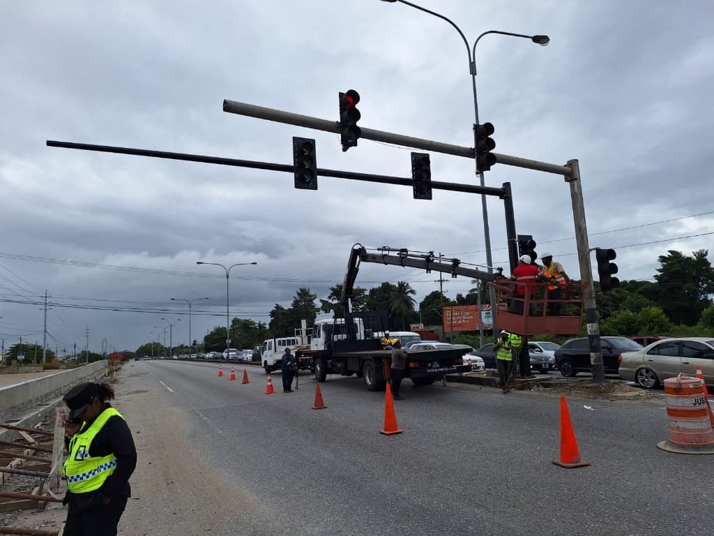 Crew installing traffic signal hardware from a roadside lift