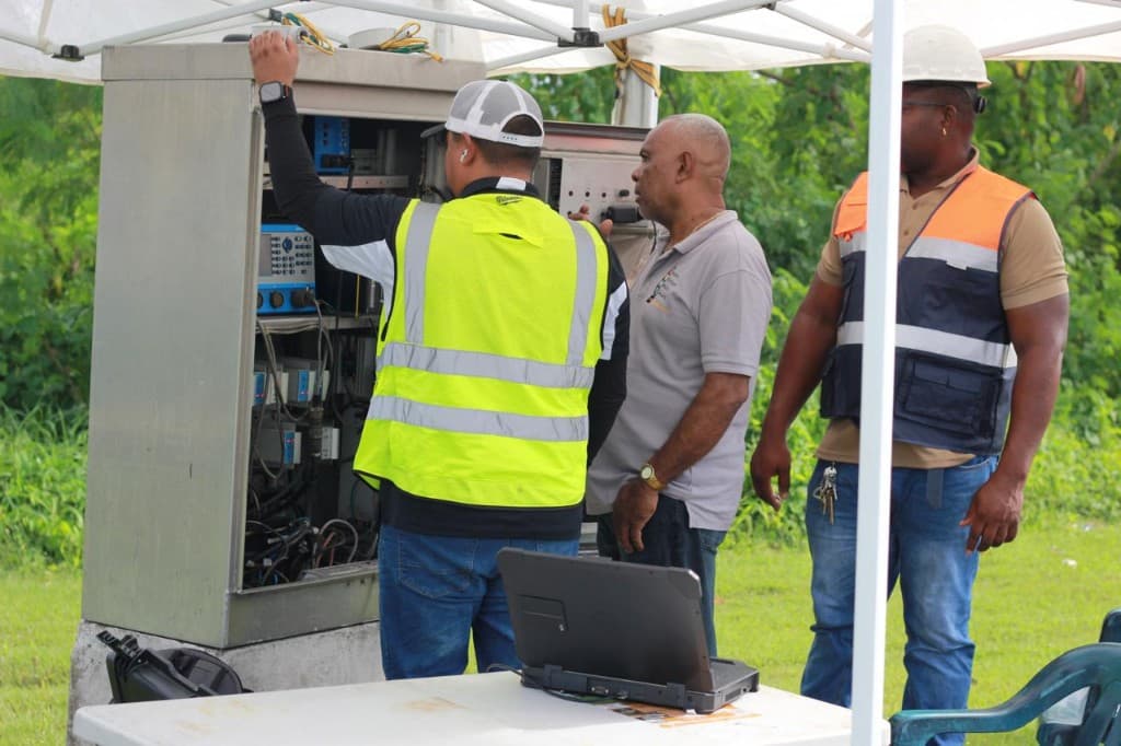 Technicians working beside an open signal control cabinet