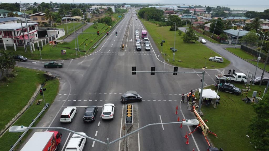 Aerial view of a multi-lane signalized intersection with a maintenance crew and lift equipment onsite